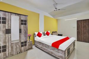a bedroom with a large bed with red pillows at Hotel Relax Inn in Gandhinagar