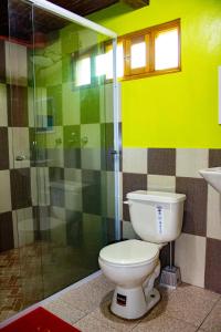 a bathroom with a toilet and a glass shower at Hostal El Inca in Chucchilán
