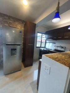 a kitchen with a stainless steel refrigerator and a counter at 55-7 Lindo y céntrico apto. in Panama City