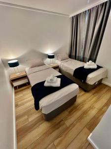 two beds in a small room with wood floors at Ultimo in Sydney