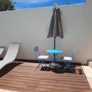 een tafel en twee stoelen en een parasol op een patio bij Studio avec piscine, idéalement situé in Saint-Claude