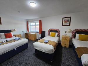 a hotel room with two beds and a desk at Collingwood Hotel in Blackpool