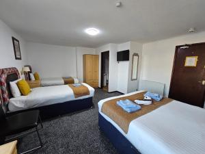 a hotel room with two beds and a television at Collingwood Hotel in Blackpool