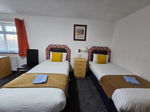 a hotel room with two beds and a chair at Collingwood Hotel in Blackpool