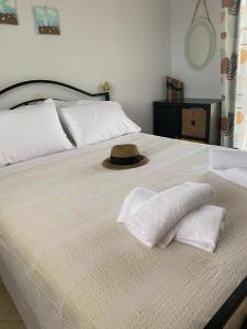 ein Bett mit zwei Kissen und einem Hut darauf in der Unterkunft Gianna's house in Nikiti