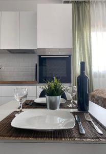 einen Tisch mit einem weißen Teller und einer Flasche Wein in der Unterkunft Gianna's house in Nikiti