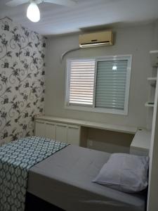 a bedroom with a bed and a window at Aluguel por temporada em Cuiabá in Cuiabá