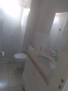 a white bathroom with a sink and a toilet at Aluguel por temporada em Cuiabá in Cuiabá