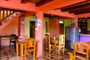 a restaurant with a table and chairs and a refrigerator at Hostal El Inca in Chucchilán