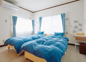 PEDAL TERRACE في إيدا: سريرين في غرفة ذات أغطية زرقاء
