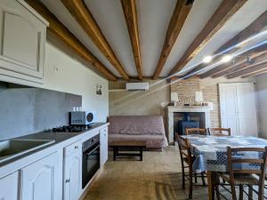 a kitchen and living room with a table and a couch at Maison de charme en Berry - proche Zoo de Beauval et Cité médiévale de Loches - FR-1-591-169 in Arpheuilles