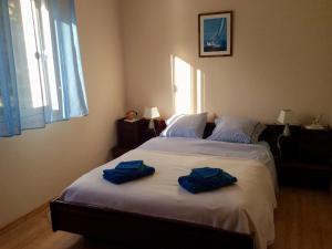 two blue towels on a bed in a bedroom at Gîte spacieux avec jardin clos et accès mer à 100m, proche commerces - Saint-Brévin-les-Pins - FR-1-306-1049 in Saint-Brevin-les-Pins