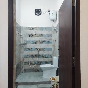 y baño con ducha y aseo. en Maha Periyava Kuteeram en Kumbakonam