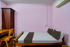 a bedroom with a bed and a wooden cabinet at Collection O Mali Residency in Pullappalli +29 photos