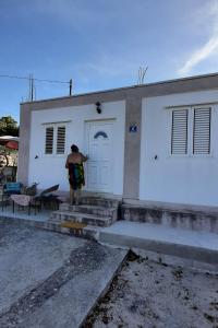 Ein Mann steht vor einem weißen Haus. in der Unterkunft Holiday house with a parking space Cove Piskera, Solta - 21775 in Grohote