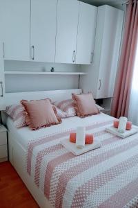 ein Schlafzimmer mit zwei Betten mit rosa Kissen und weißen Schränken in der Unterkunft Holiday house with a parking space Cove Piskera, Solta - 21775 in Grohote + 8 Fotos