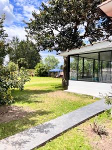 a modern house with glass windows and a lawn at Springhills Quito Airport in Tababela