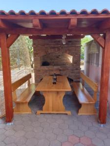 a wooden picnic table with a stone fireplace at Apartments and rooms with parking space Povljana, Pag - 22707 in Povljana
