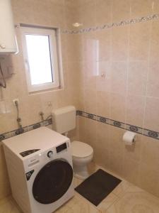 a bathroom with a toilet and a washing machine at Apartments and rooms with parking space Povljana, Pag - 22707 in Povljana