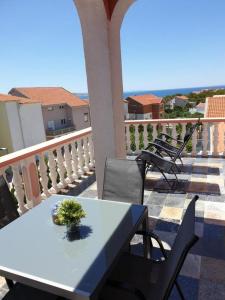 un tavolo e sedie su un balcone con vista sull'oceano di Apartments and rooms with parking space Povljana, Pag - 22707 a Povljana (Pogliana)