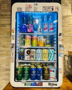 um frigorífico cheio de garrafas e latas de refrigerante em Act Hotel Roppongi em Tóquio