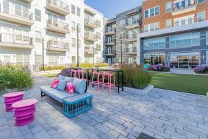 eine Terrasse mit einem Sofa und rosa Hockern vor einem Gebäude in der Unterkunft Modern Luxury Sanctuary Apt in DownTown Boston in Chelsea