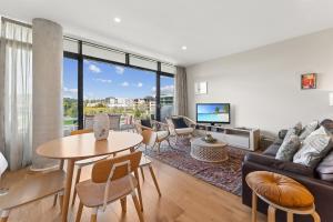 a living room with a couch and a table at Stylish 2-Bed with Amenities 10-Min from CBD in Campbell