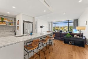 a kitchen and living room with a counter and a couch at Stylish 2-Bed with Amenities 10-Min from CBD in Campbell