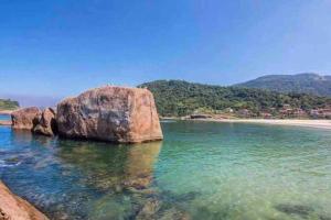 uma grande rocha na água ao lado de uma praia em Flat aconchegante em Piratininga 100 mt da praia em Niterói