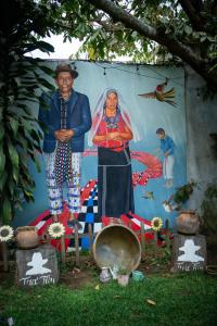 um homem e uma mulher em frente a um mural em Hotel Taa' Tiin em San Juan La Laguna