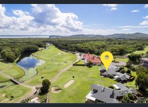 una vista aérea de un campo de golf con un cartel amarillo en Perfect weekend getaway plus golf at your doorstep, en Salamander Bay