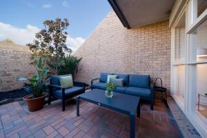 a patio with a couch and chairs and a table at Honeyeater Hidden Gem - 2BR Central Quiet in Bowden