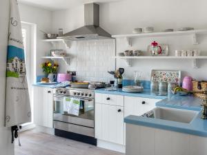 a kitchen with white cabinets and blue counter tops at The Hedgehog-uk46923 in Newby Bridge