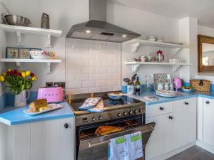 a kitchen with white cabinets and a stove top oven at The Hedgehog-uk46923 in Newby Bridge