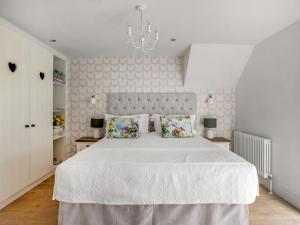 a white bedroom with a large white bed with pillows at The Hedgehog-uk46923 in Newby Bridge