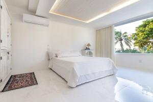a white bedroom with a bed and a large window at Porto Brasil resort, beira mar, casa com 4 suítes, piscinas in Parnamirim +44 photos