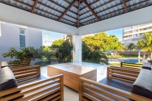a patio with two benches and a table with a view at Casa em resort, beira mar, 4 suítes, piscinas in Parnamirim