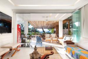 a living room with a couch and a table at Casa em resort, beira mar, 4 suítes, piscinas in Parnamirim