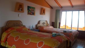 1 dormitorio con 2 camas y ventana en Inti kala lodge, en Comunidad Yumani