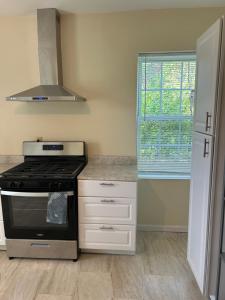 a kitchen with a stove and a window at Keur Koura in The Ville in Saint Louis +14 photos