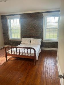 a bed in a room with a brick wall at Keur Koura @The Ville in Saint Louis