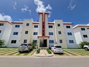 a building with two cars parked in front of it at Sunset Home 2B (Gated) in Higuey