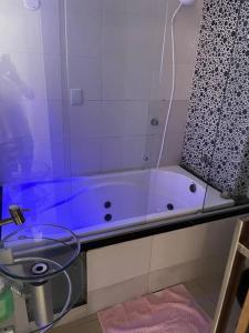 y baño con ducha y bañera azul. en Apartamento Salvador/200m da praia., en Salvador