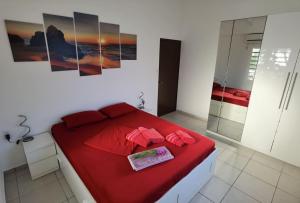 a bedroom with a red bed and a glass shower at Roadrunner-Bonaire in Kralendijk