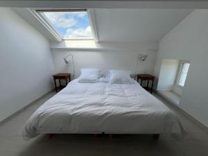 a bed in a white room with a window at Superb villa with private pool in Banne