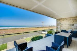 uma sala de jantar com vista para a praia em 52 Esplanade - BYO Linen - Luxury - Seafront - Wi-Fi em Middleton