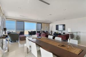 uma sala de estar com uma mesa de jantar e uma sala de estar em 52 Esplanade - BYO Linen - Luxury - Seafront - Wi-Fi em Middleton