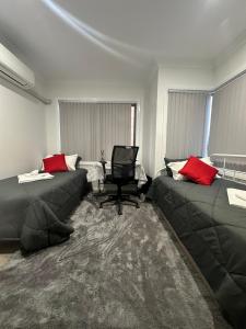 uma sala de estar com dois sofás e uma cadeira em Private Room in Townhouse em Wollongong