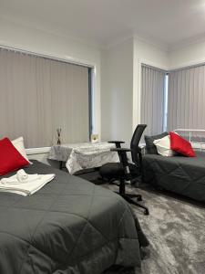 um quarto com 2 camas, uma secretária e uma cadeira em Private Room in Townhouse em Wollongong