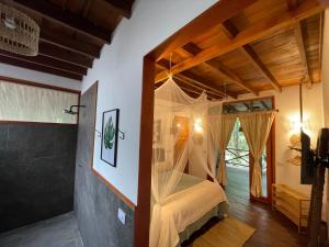 a bedroom with a canopy bed in a house at El Retiro De Carolina in Santa Marta